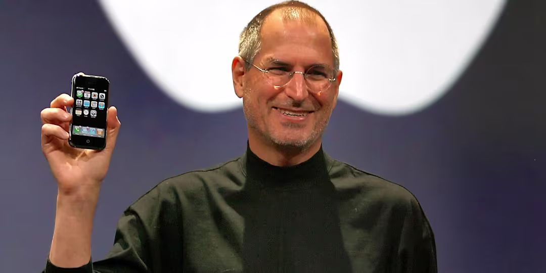 Steve Jobs holding the first iPhone.